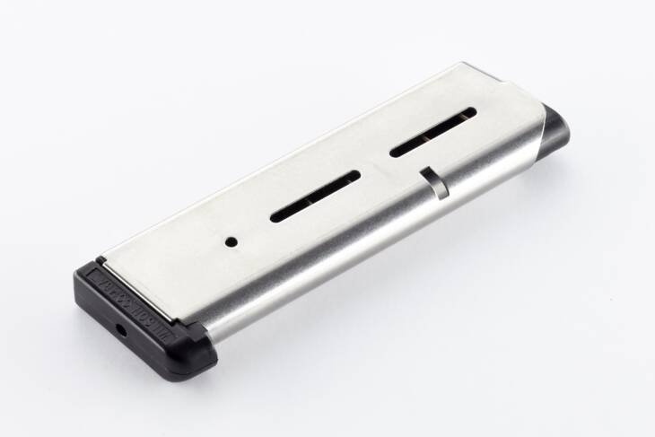 Sleek silver magazine with matte black base and round indicator slots for firearms.