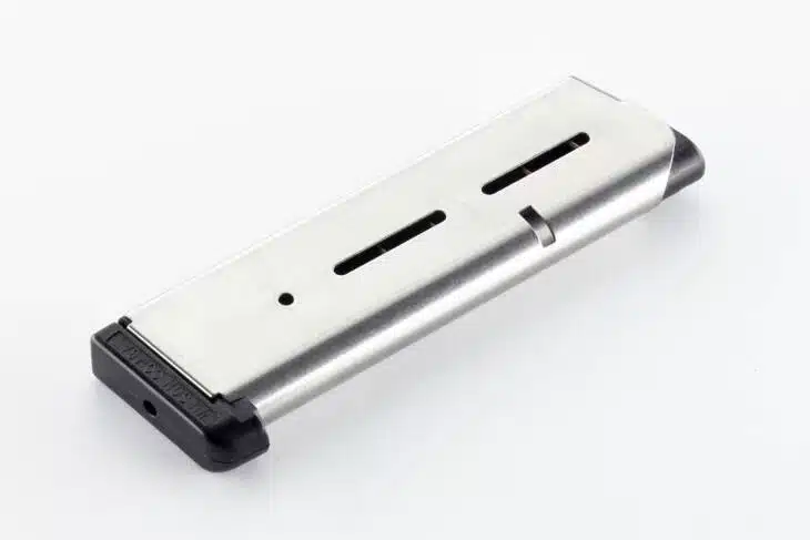 Sleek silver magazine with matte black base and round indicator slots for firearms.