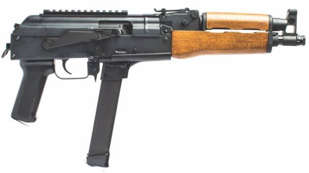 Modern compact firearm with wood accents, tactical rail, and short barrel for close-quarters adaptability.