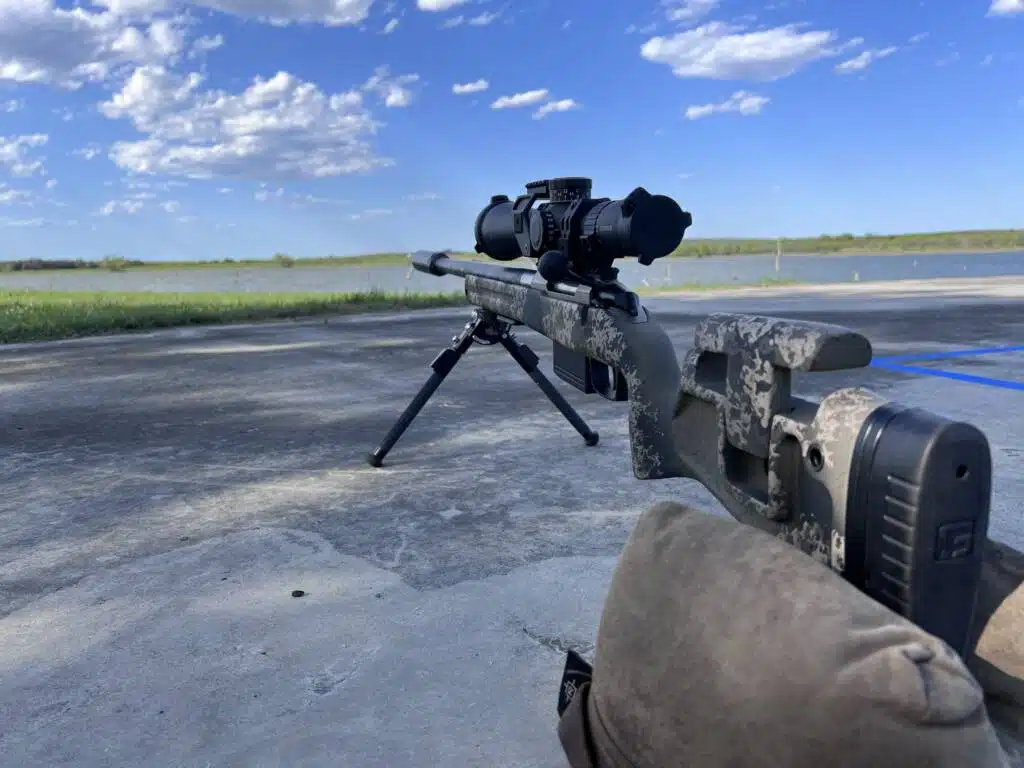 Tactical precision rifle setup in a tranquil landscape for competitive shooting and marksmanship training.